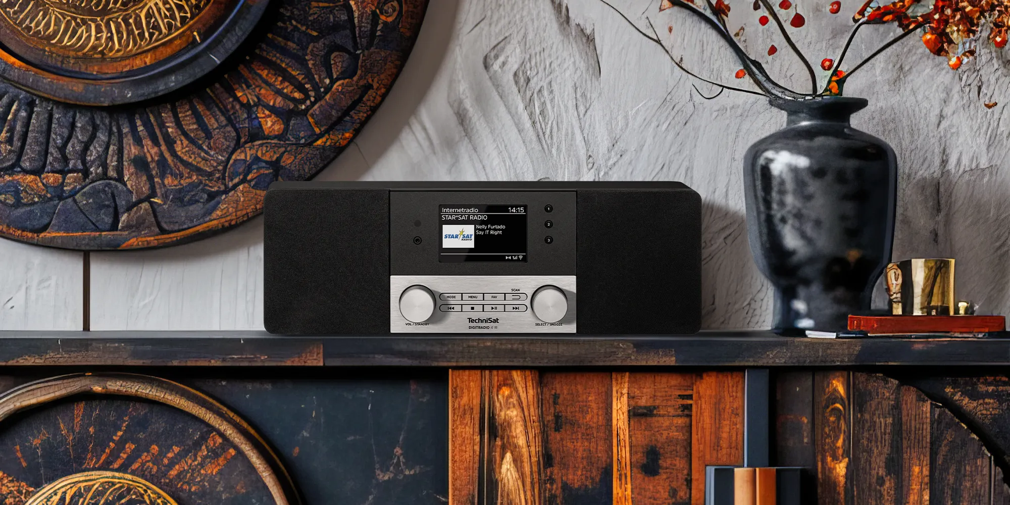 Ein Internetradio steht auf einem Sideboard mit Souvenirs aus fernen Ländern – das Ambiente wirkt weltoffen und exotisch.