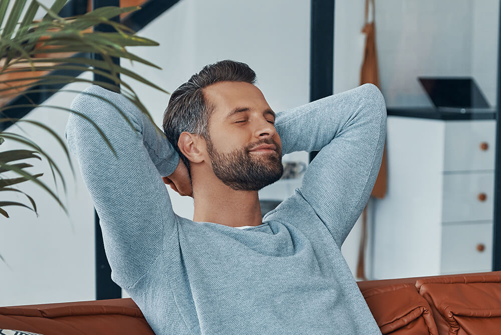 Mann sitzt auf der Couch und genießt hohe Audioqualität aus der Kombination von einem TechniSat Radio und Spotfiy Connect.